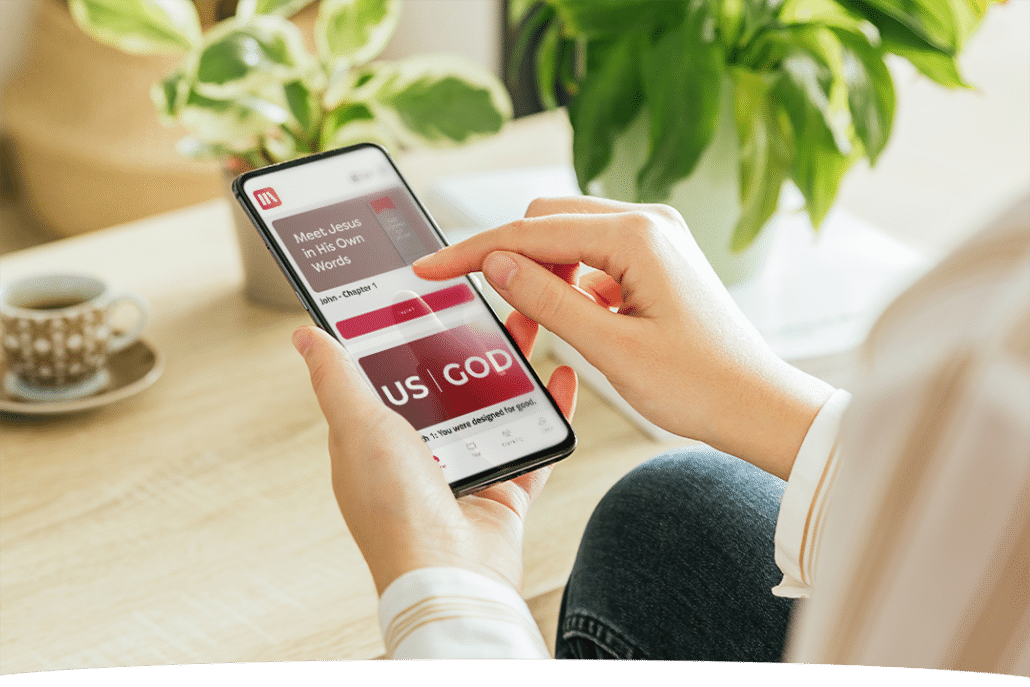 READ CARRY SHARE A person uses a smartphone at a table with a cup of coffee and plants nearby. The phone screen displays a religious website about meeting Jesus.